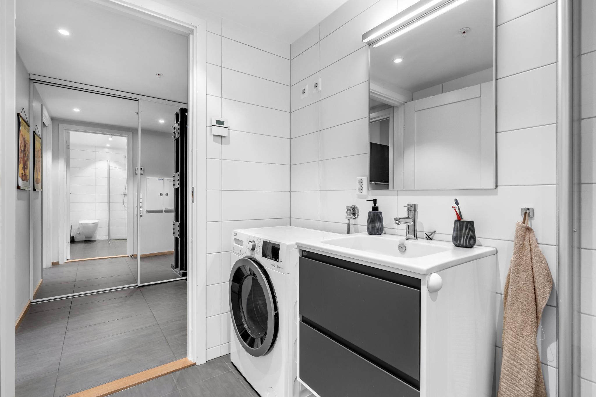 Servant med praktiske skuffer og opplegg for vaskemaskin.

